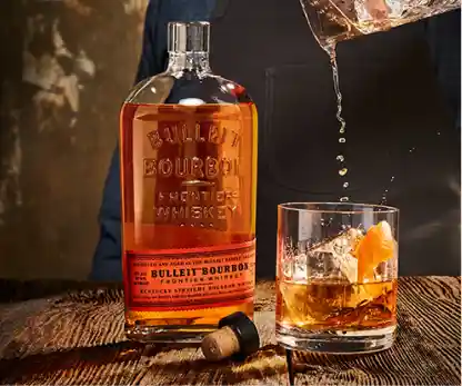 Botella de whisky bourbon Bulleit servida en vaso de cata