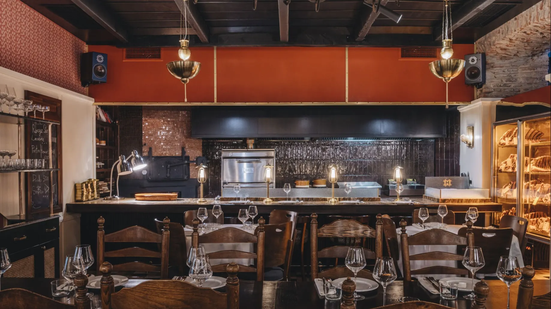 Una parrilla imponente, vitrinas con cortes nobles y una iluminación cálida que invita a rendirse ante el arte del fuego y la buena carne.