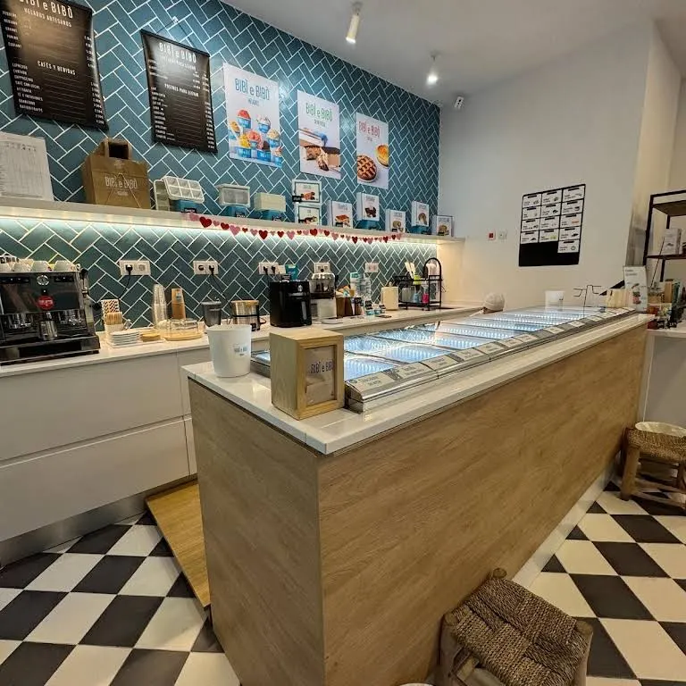 Mostrador de madera, suelos ajedrezados y azulejos turquesa en Bibi e Bibò Alcalá, con carta visual y ambiente cuidado y luminoso.