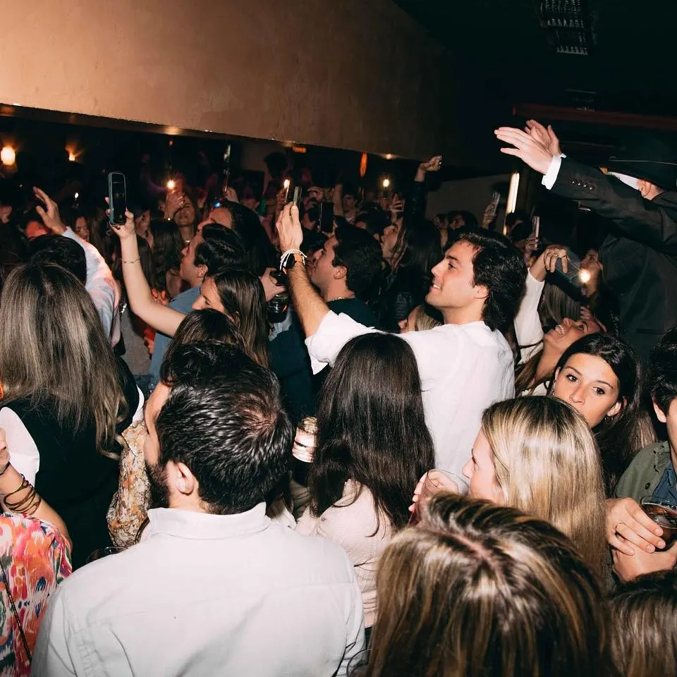 Julius con una multitud vibrante disfrutando de una noche festiva, música en vivo y energía desbordante en un espacio lleno de vida.
