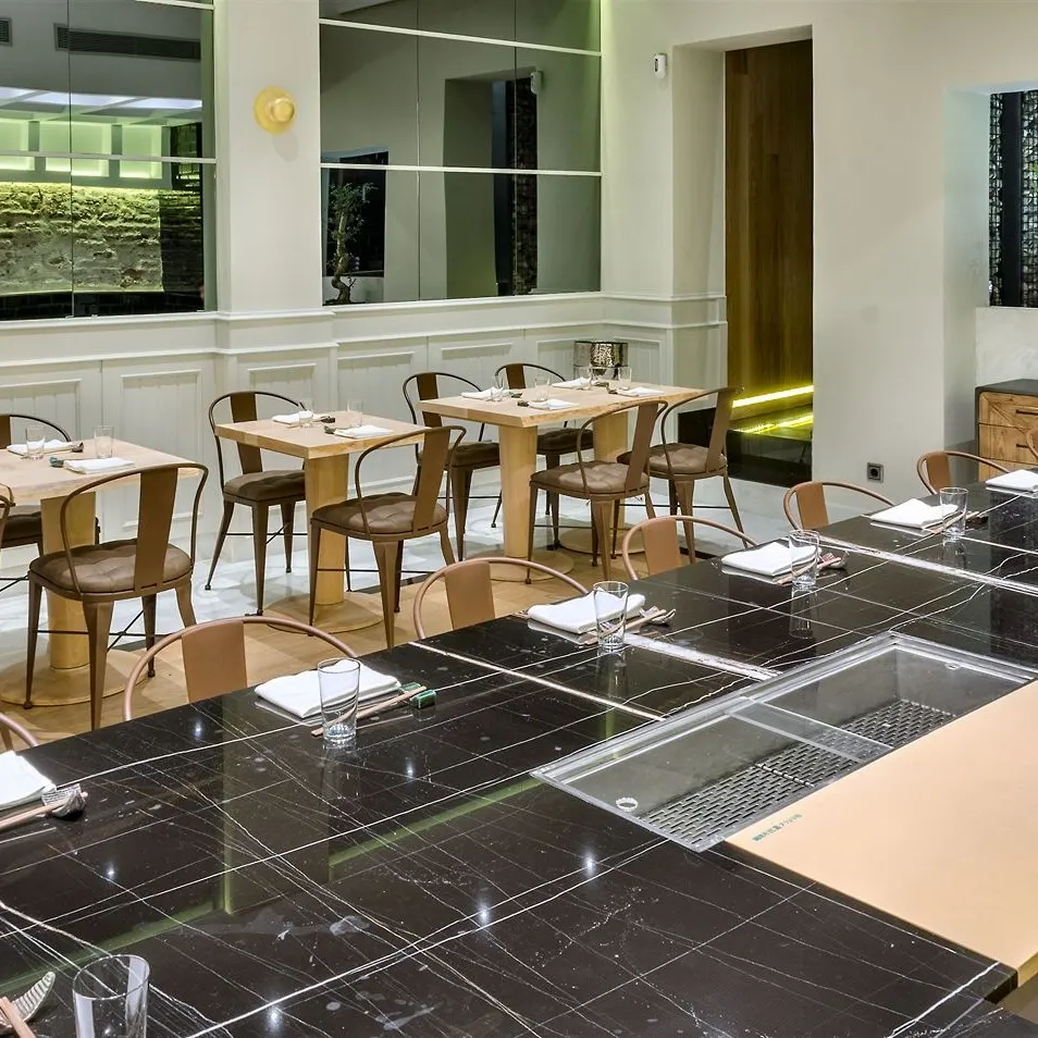 Vista del interior de Kappo, con su barra negra lista para el showcooking y un ambiente minimalista que mezcla tradición japonesa con elegancia moderna.