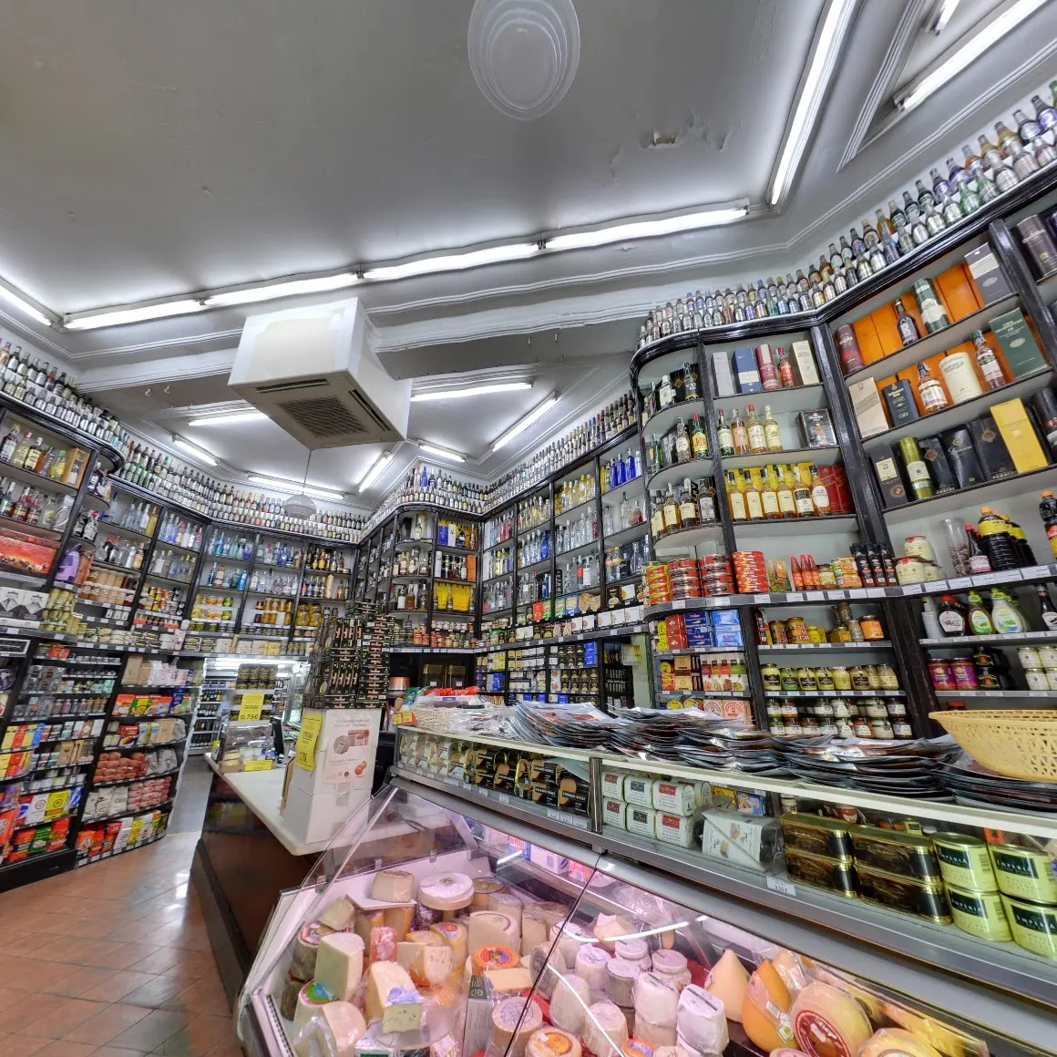 Colmado Quílez, una tienda tradicional de productos gourmet en Barcelona, con estanterías llenas de licores, conservas y una gran variedad de quesos.
