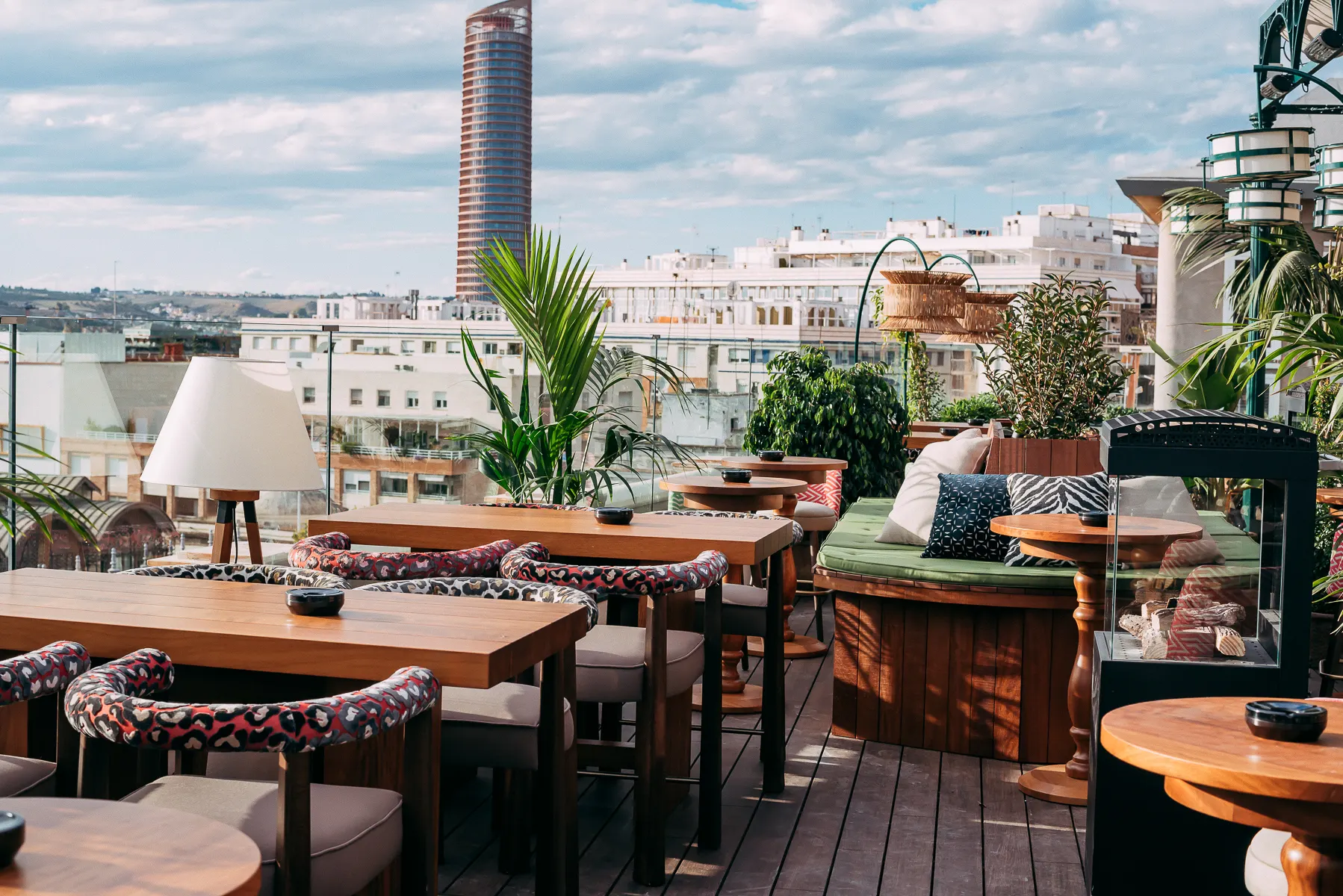 En Ático, la decoración exuberante se mezcla con una vista privilegiada de la Giralda, creando un rincón mágico para brindar sobre los tejados de Sevilla.
