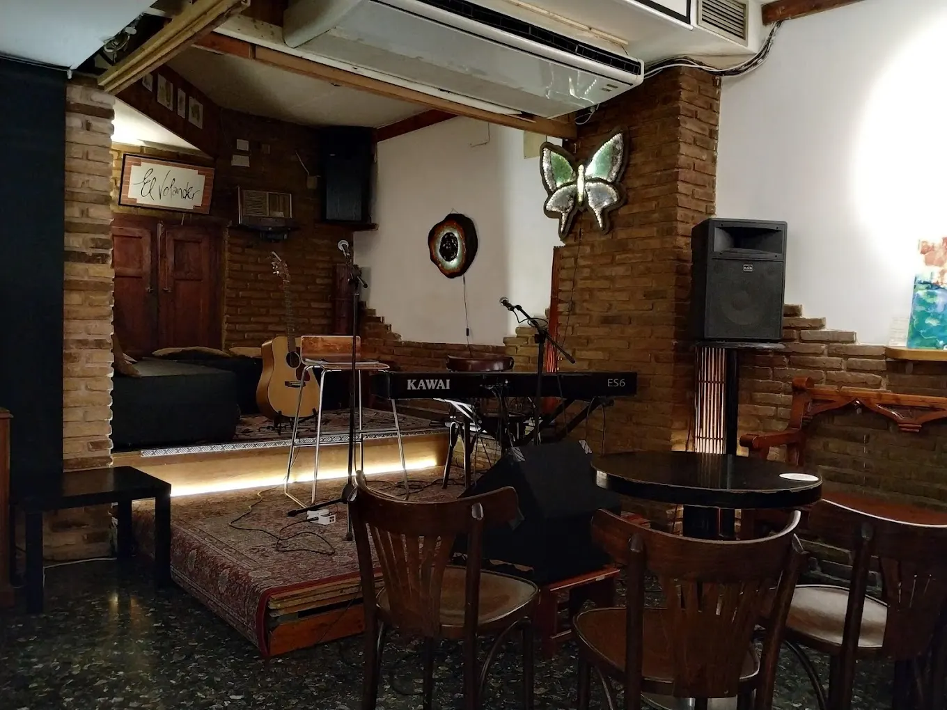 El Volander, un espacio íntimo con escenario de madera, iluminación cálida y un ambiente acogedor ideal para conciertos acústicos y poesía en vivo.