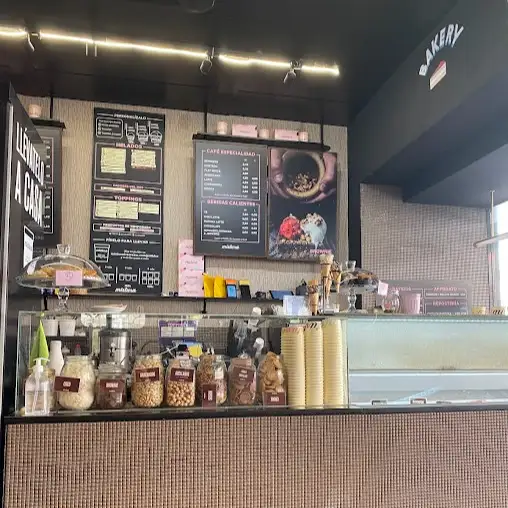 Vista del mostrador de Mistura Goya con tarros de toppings, cucuruchos apilados y decoración moderna en tonos neutros.