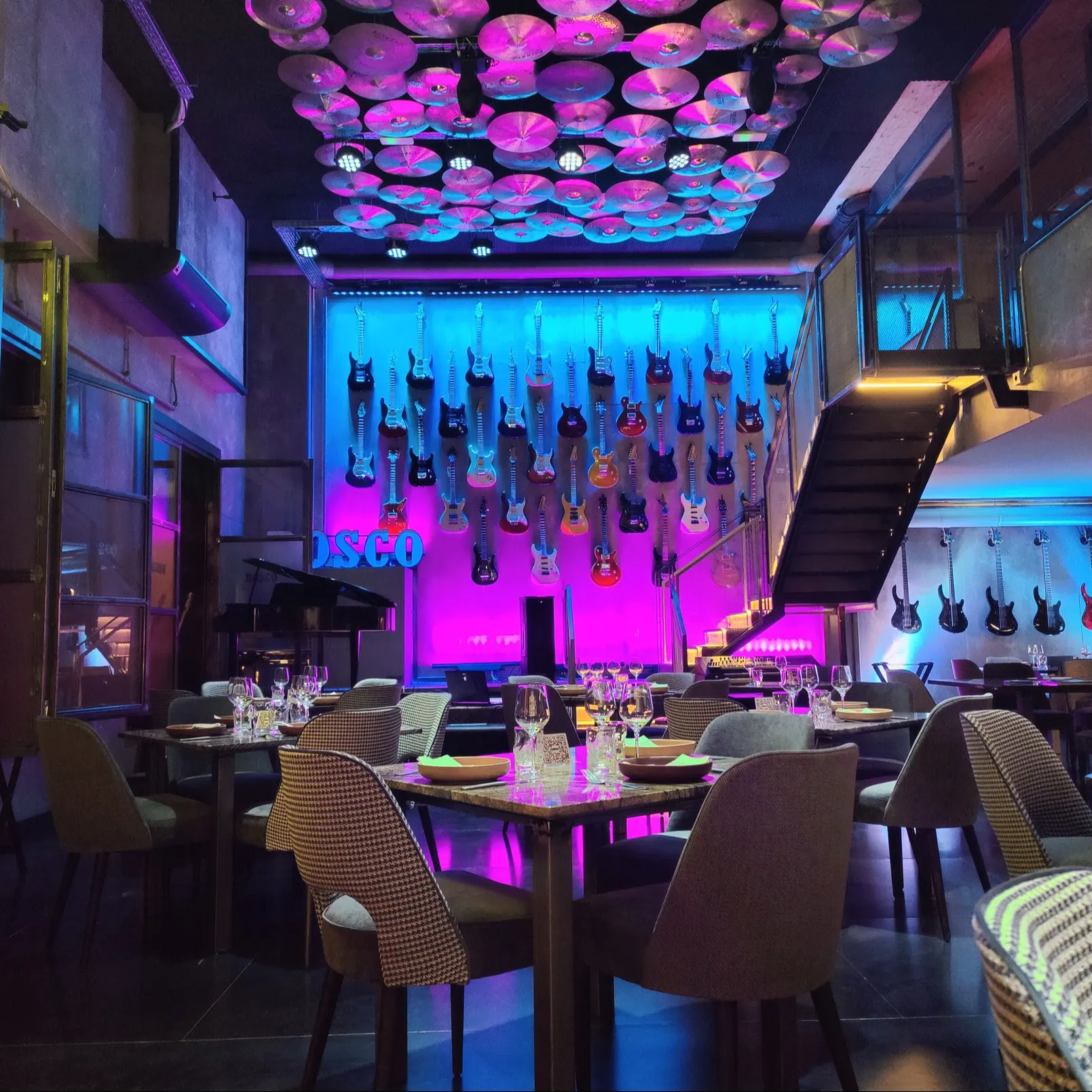 Un espacio vibrante con guitarras iluminadas y techos decorados con platillos, Bosco combina buena comida con un ambiente lleno de música y estilo.