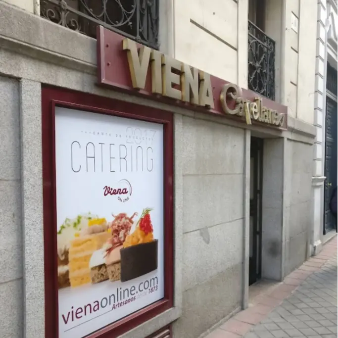 Entrada lateral de Viena Capellanes en Ruiz de Alarcón, con rótulo clásico y cartel promocional de su servicio de catering artesanal.