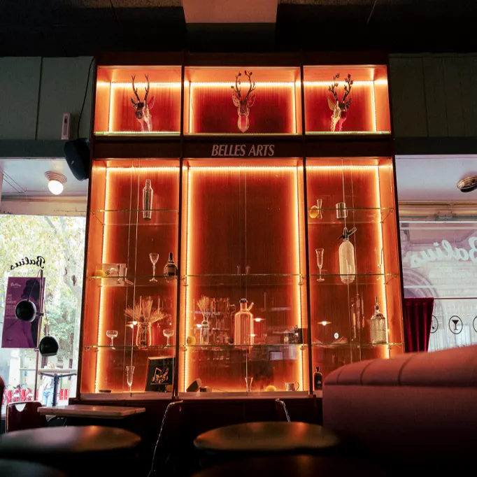 Balius Bar deslumbra con su vitrina iluminada llena de arte mixológico y un ambiente que mezcla elegancia retro y modernidad.