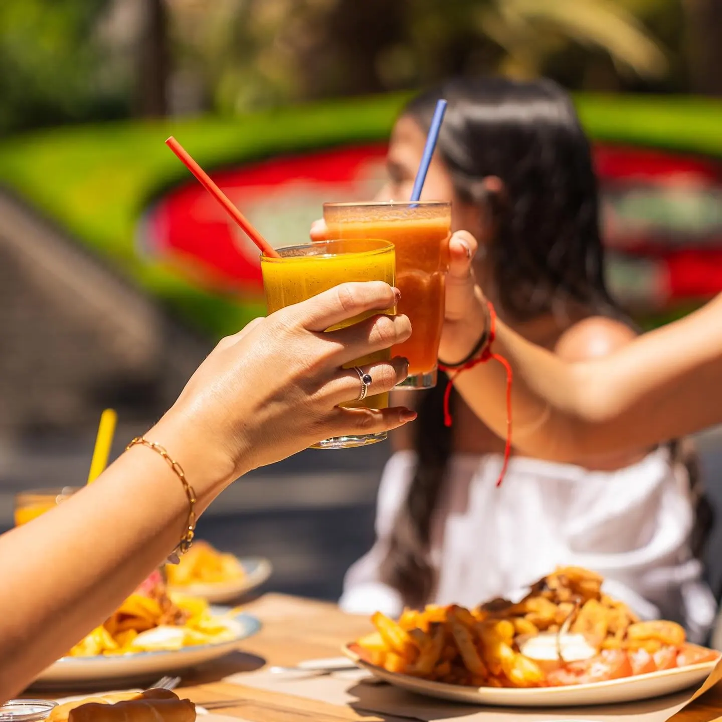 Terraza Parque con un brindis refrescante bajo el sol, acompañado de comida deliciosa y un ambiente relajado al aire libre.