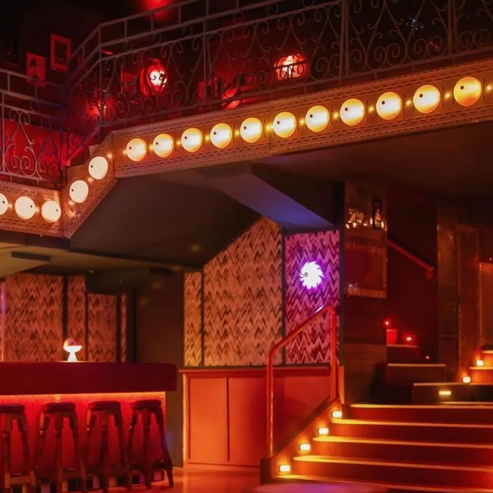 Salvaora Brown: Un espacio con una atmósfera íntima y sofisticada, iluminado suavemente para crear un ambiente acogedor. La decoración incluye detalles vintage y un elegante juego de luces que resalta su diseño retro y moderno a la vez.