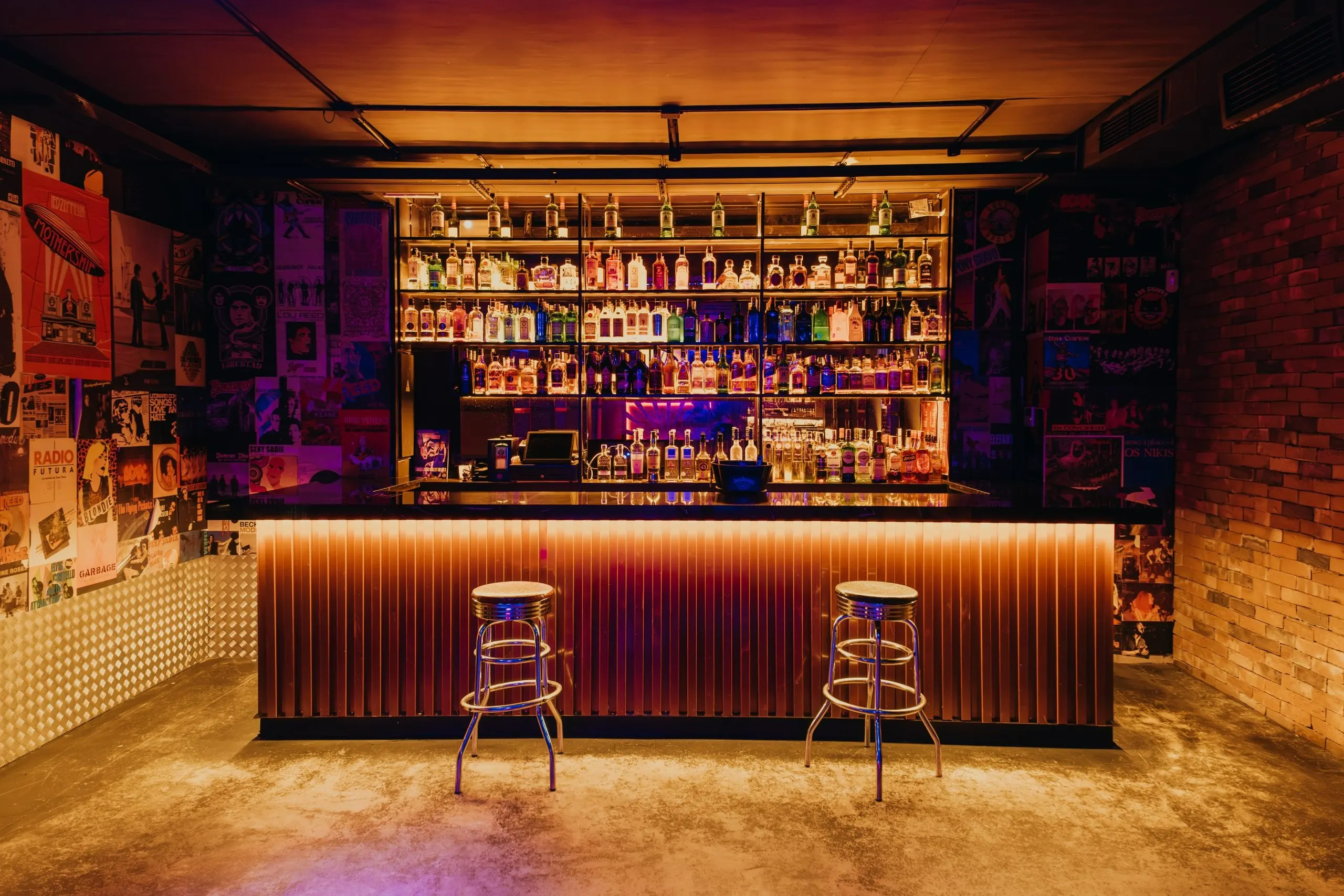 La foto muestra un espacio interiorde la Sala Fun Club. Hay varias bolas de discoteca colgando del techo, proyectando patrones de luz reflectante por toda la habitación. Las paredes están adornadas con elementos de ladrillo y madera.