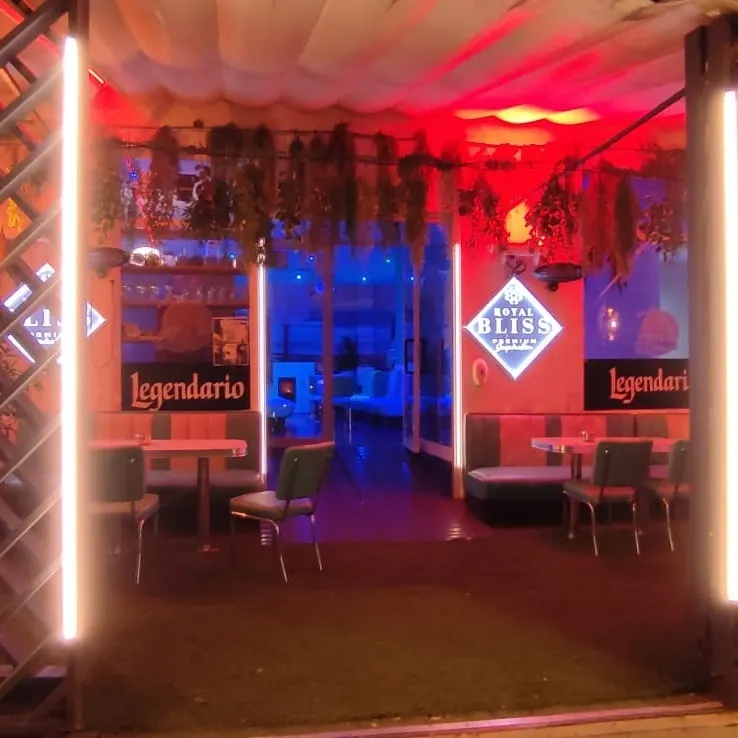 El Palmar Montequinto presenta una entrada iluminada con tonos cálidos y detalles de madera, invitando a disfrutar de su acogedor interior.