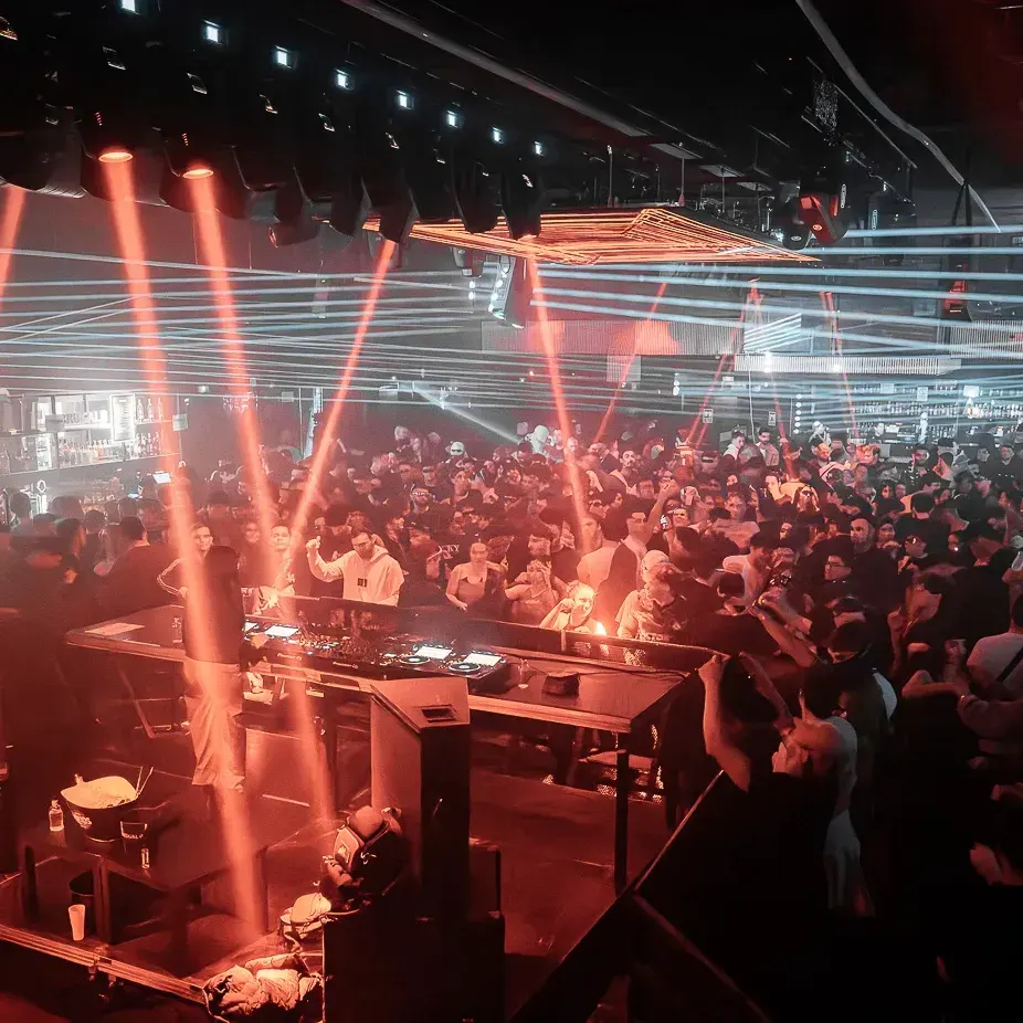 Sala Pandora, una multitud vibrante, luces láser impactantes y un DJ que domina el escenario para crear una noche llena de energía y ritmo.
