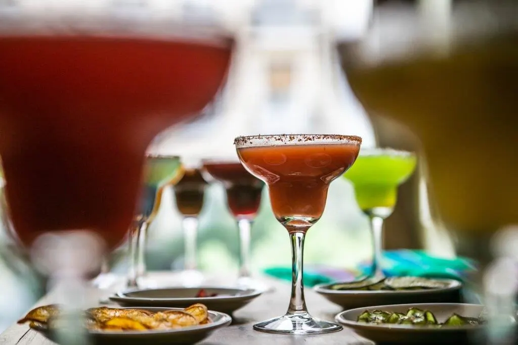 Xamach reúne a amigos alrededor de una mesa llena de sabores mexicanos, compartiendo salsas, guarniciones y risas en un ambiente cálido y festivo.