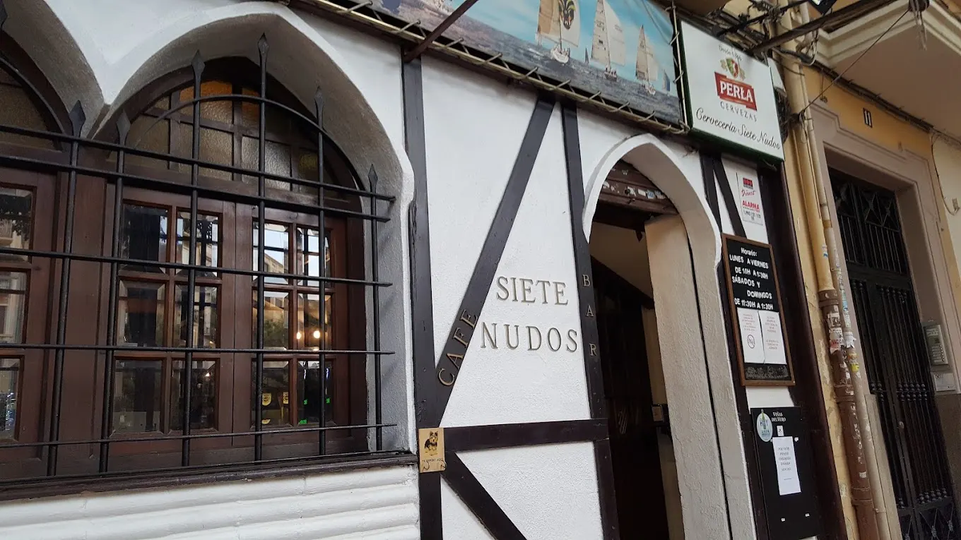 Fachada de Siete Nudos con detalles de entramado de madera, ventanas enrejadas y un cartel náutico que remite al espíritu marinero del local.