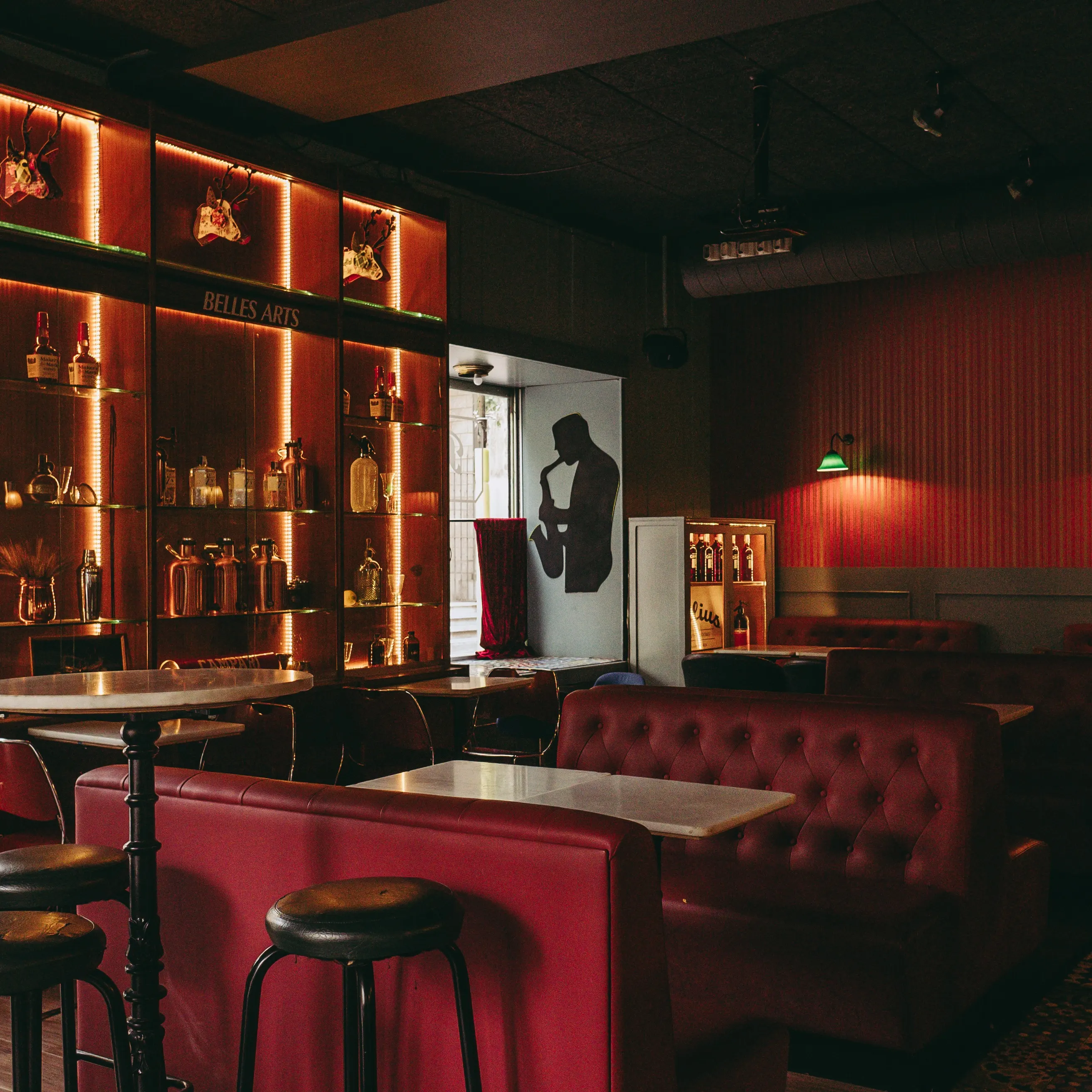 Balius Bar deslumbra con su vitrina iluminada llena de arte mixológico y un ambiente que mezcla elegancia retro y modernidad.