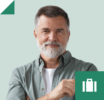 Bearded man in a grey button down shirt holding his glasses.