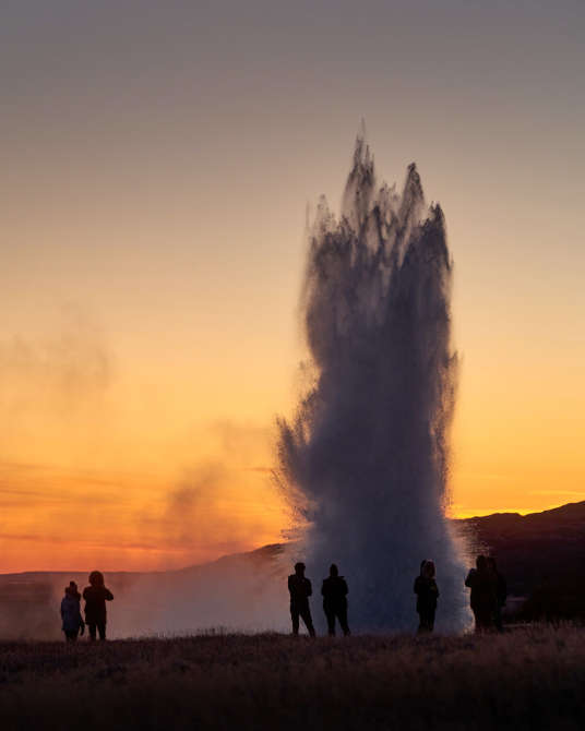Strokkur geyser erupting in the sunset