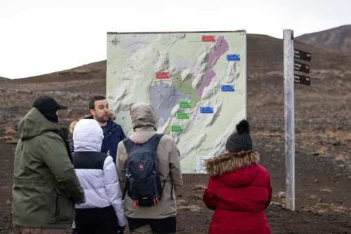 A group of hikers near a large map display