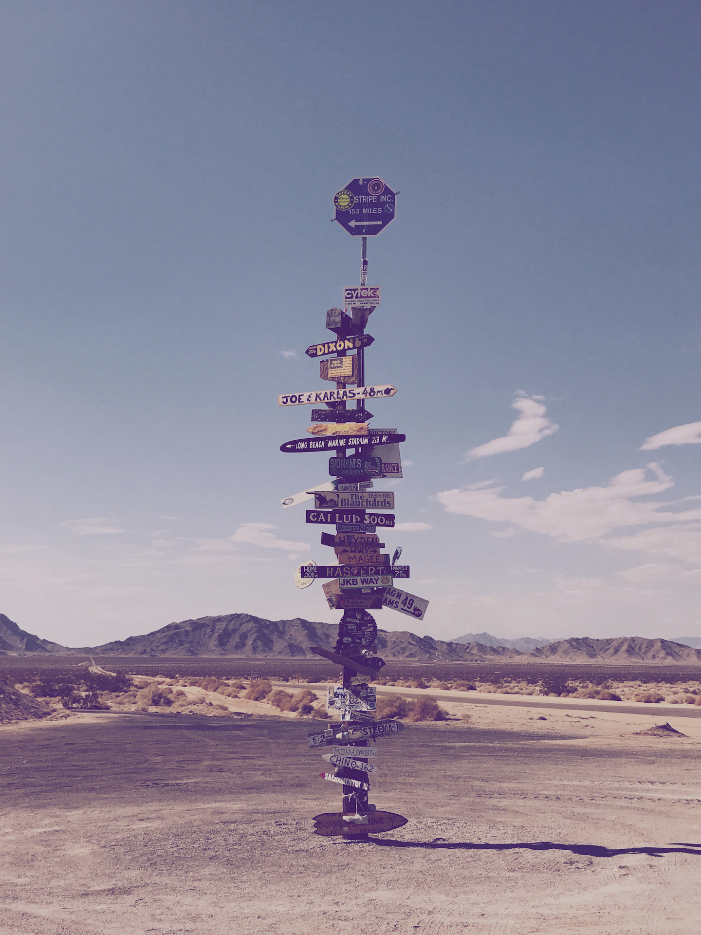 Ein grosses Bild eines Postens voll mit Schildern in der Wüste | HudsonGoodman