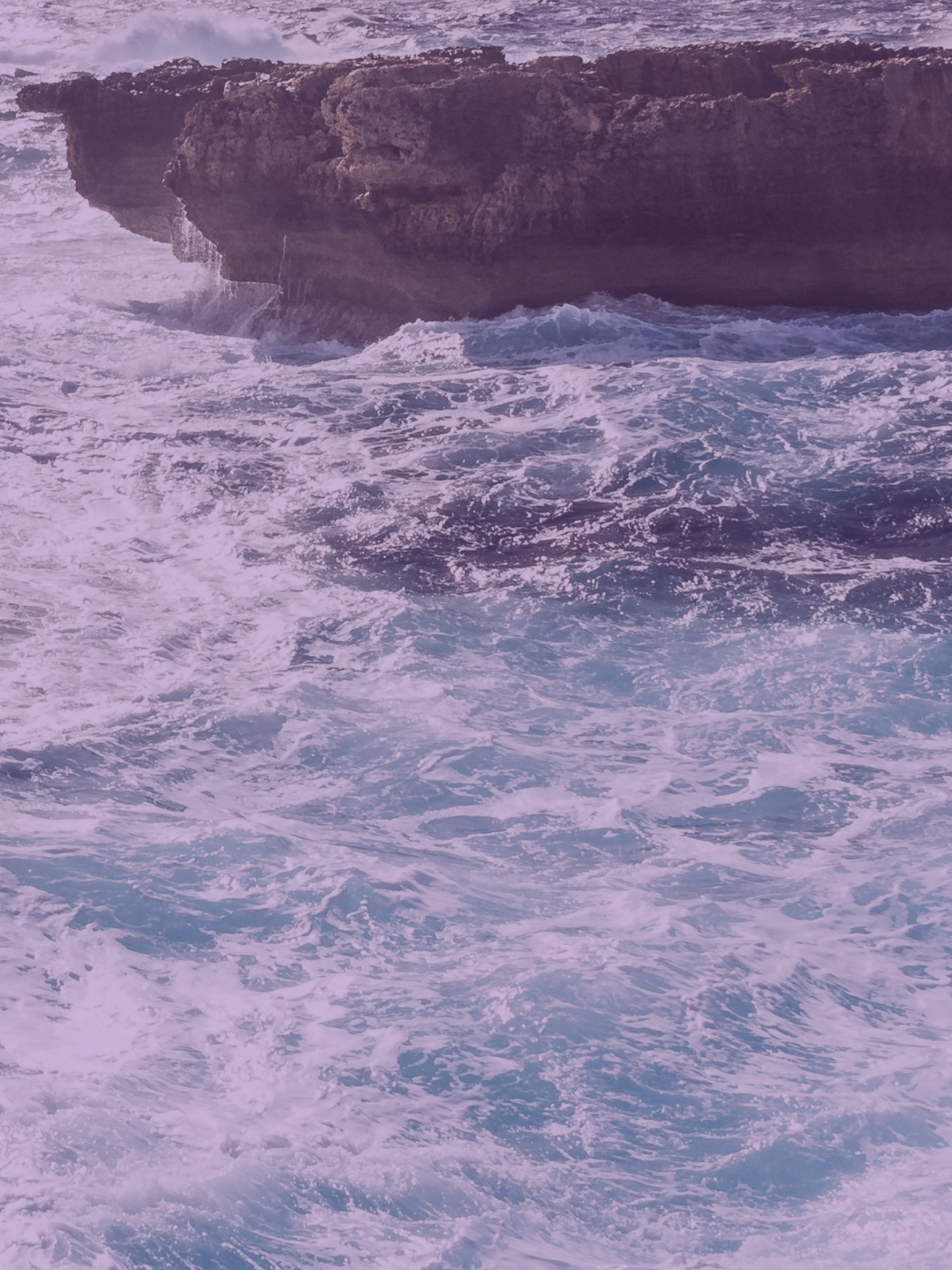 header 3 ein paar wellen die gegen einen felsen krachen