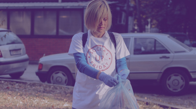 Frau, die Müll sammelt und ein Social Friday Logo Shirt trägt