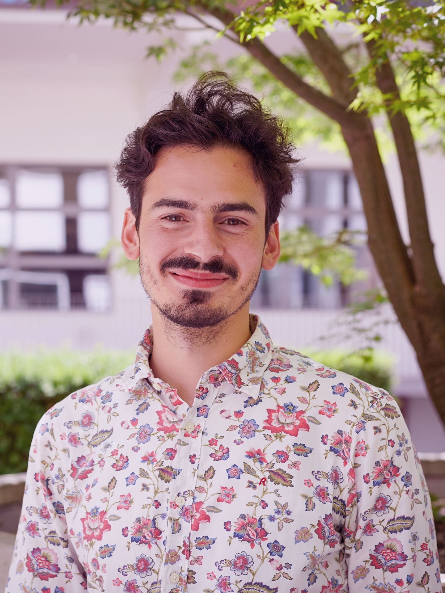 Header image: Pablo Villars steht vor einem Baum