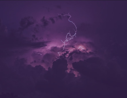 Ein Blitz einem lila gefärbten Himmel 