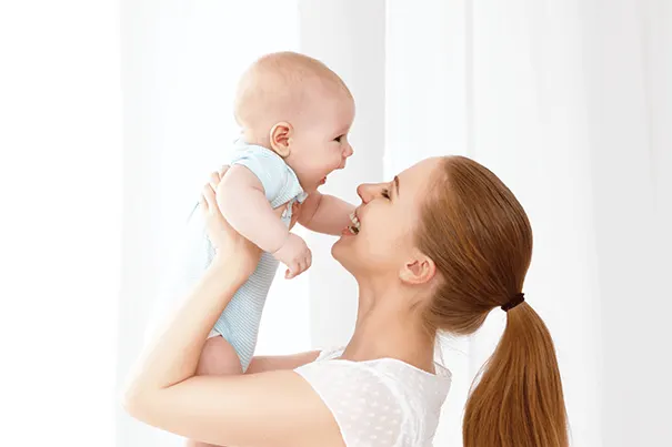 mom holding up baby