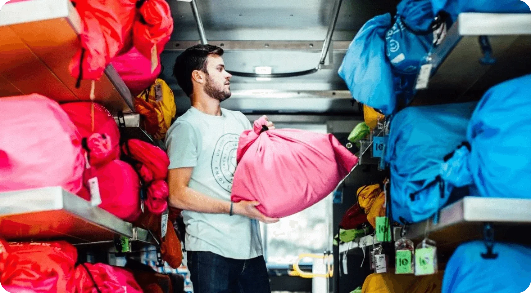 A Tide Cleaners employee holding a clean bag of laundry.