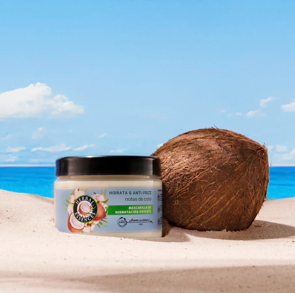 La Mascarilla Capilar Hidratación potente en la playa junto a un coco