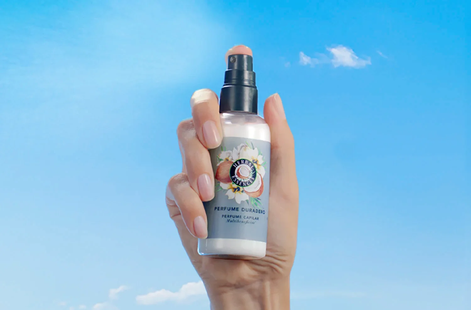 Una mano sosteniendo el Perfume Capilar Duradero con notas de coco