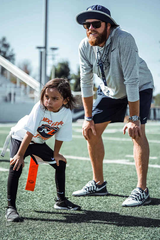 Coach working with a young player on the field