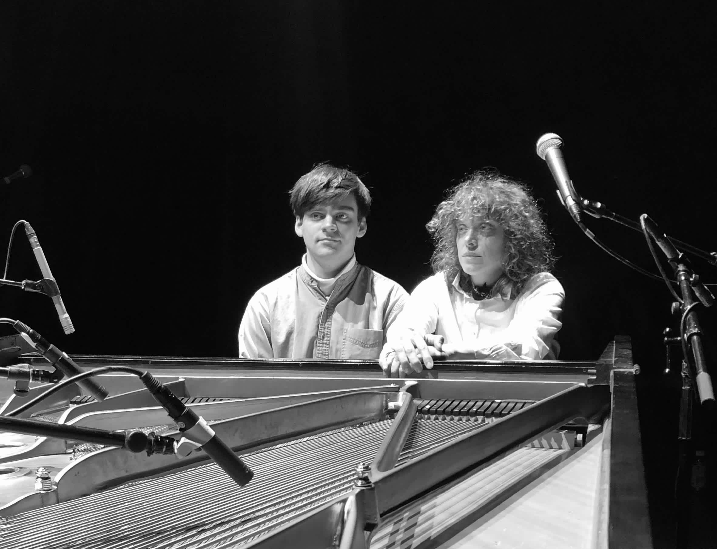 Max Eilbacher and Ka Baird seated at a piano.
