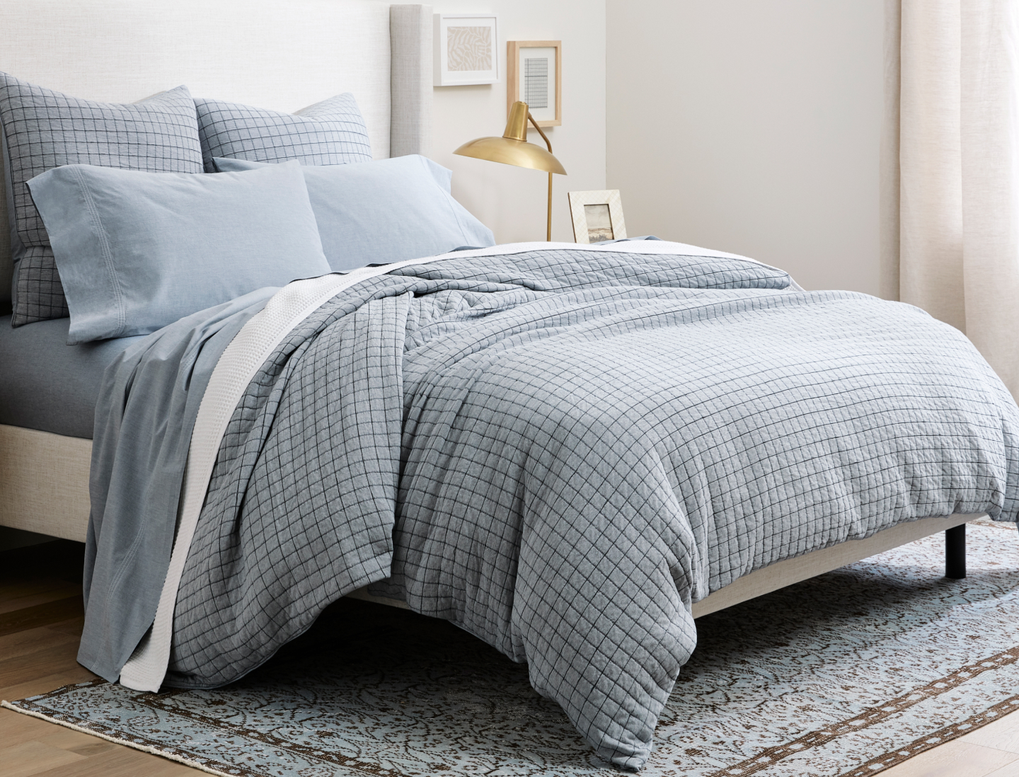 Bed made with Chambray Triple Stitch Sheet Set and Matelasse Windowpane Duvet Set in Chambray Blue