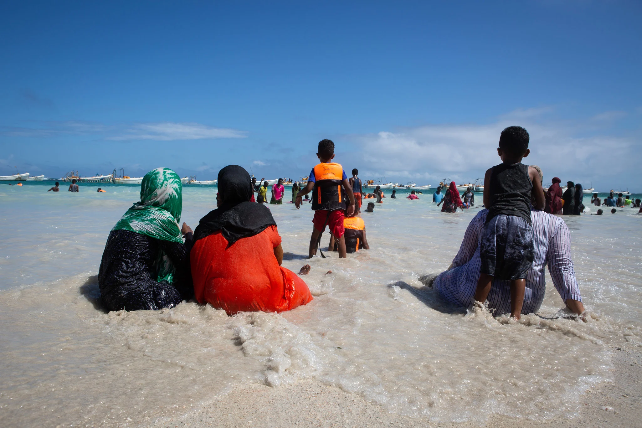 A mother and her children face the ocean at the beach in Liido, Mogadishu