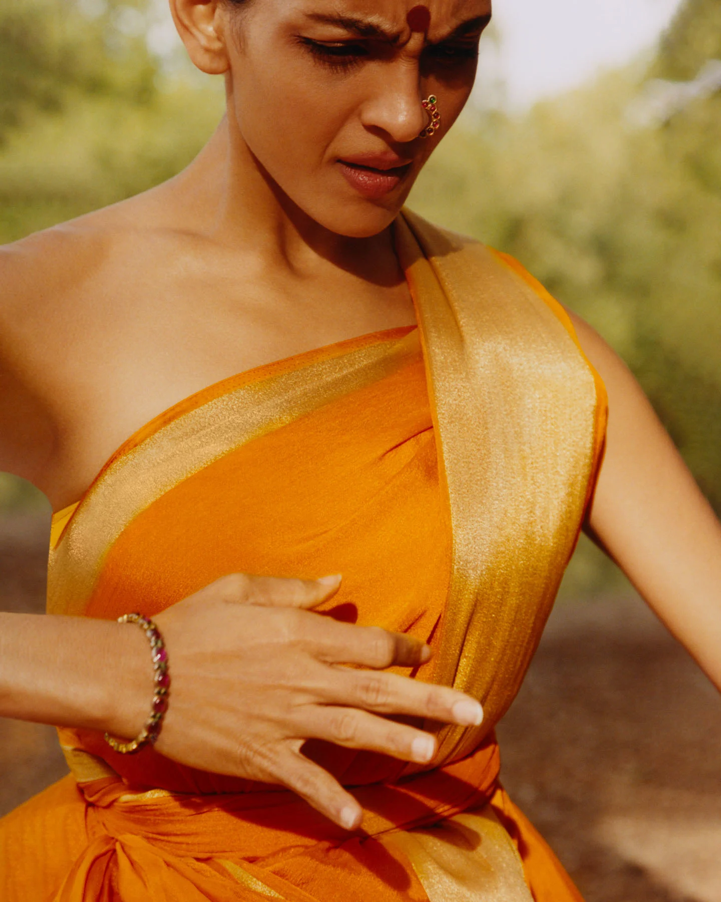 A photograph of Bharatanatyam dancer Rukmini Vijayakumar, dancing with full concentration in nature.