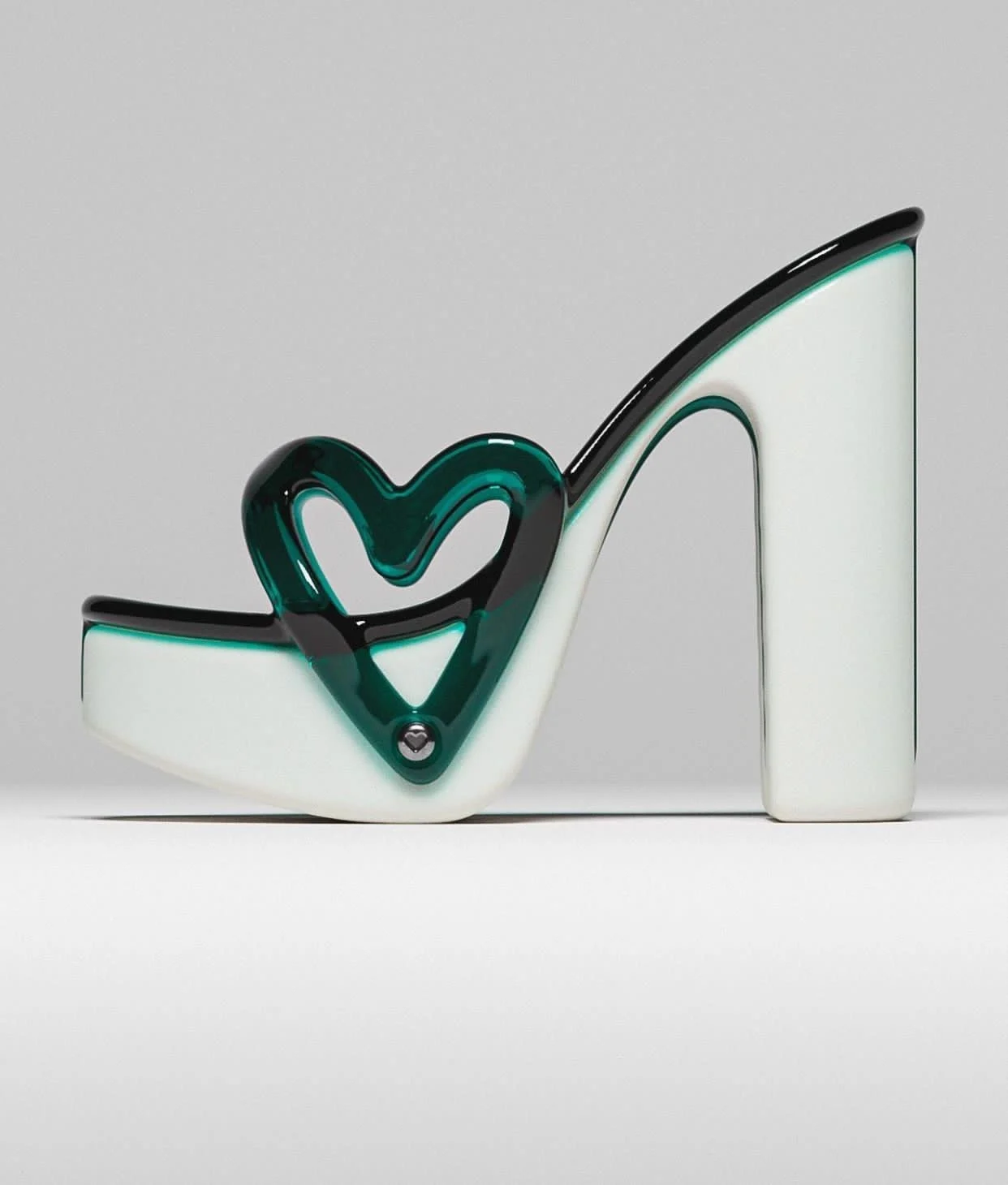 A white and green high-heeled shoe with a heart on its side.