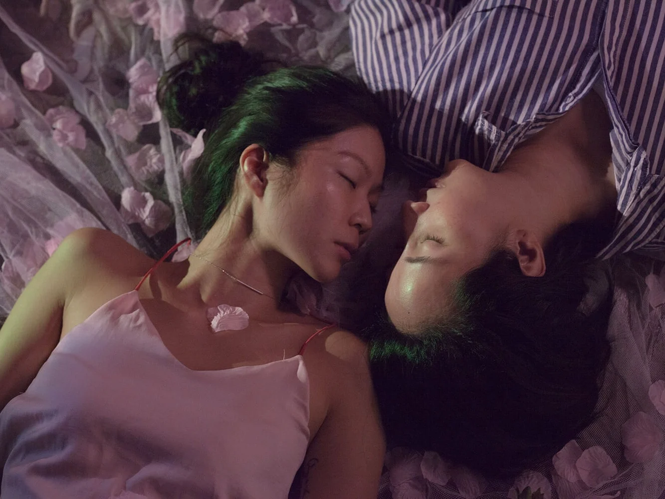 Ele and Lee lie facing each other. The two don't prioritise official marriage, although they do see themselves in a long-term partnership, and imagine a life together outside of Singapore.