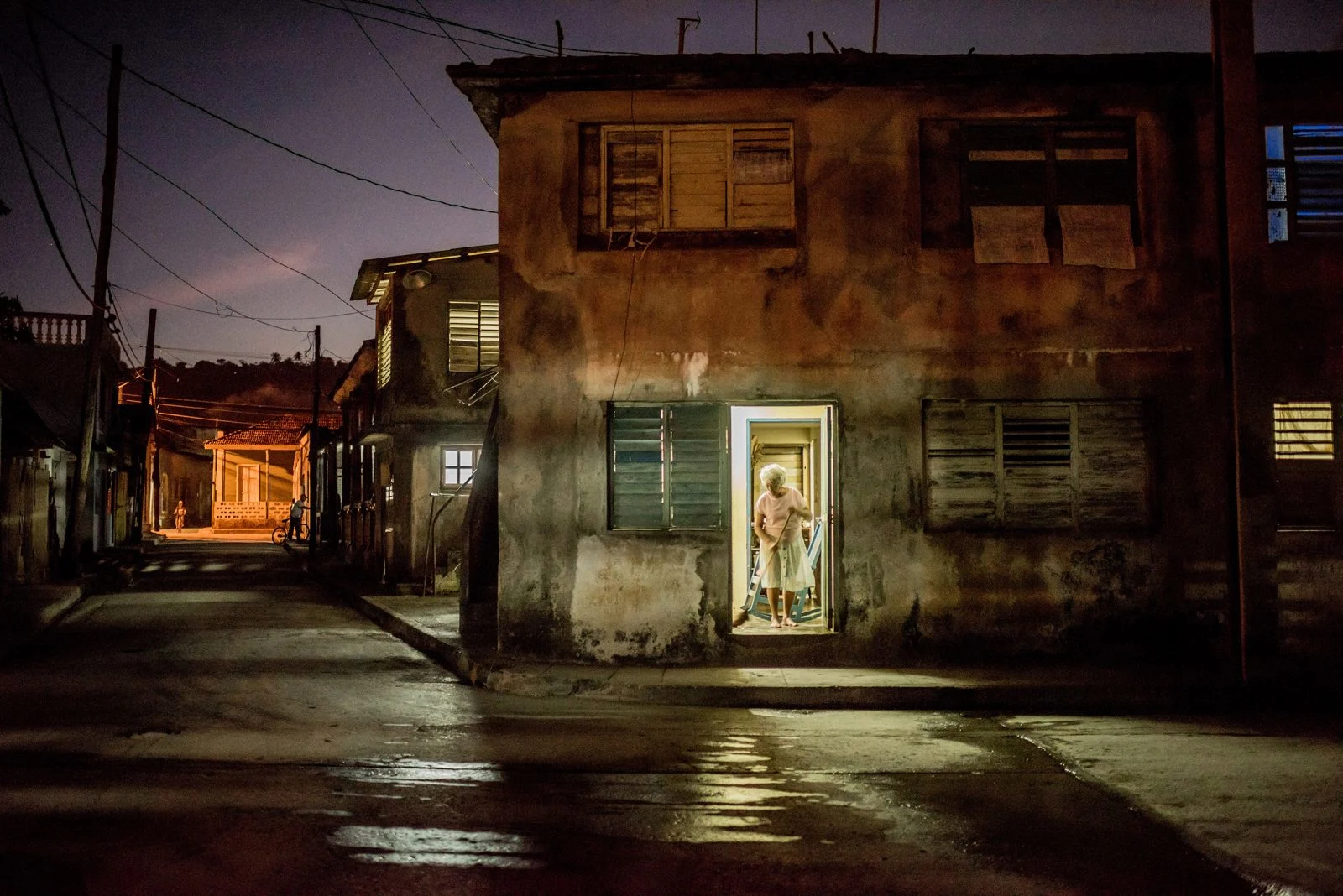 Framed in her doorway, a woman swept her home in Baracoa, Cuba, on January 25, 2016.