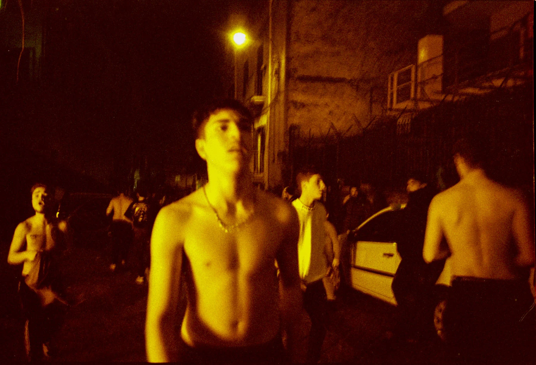 A photo of a group of teenage boys playing in the street at night
