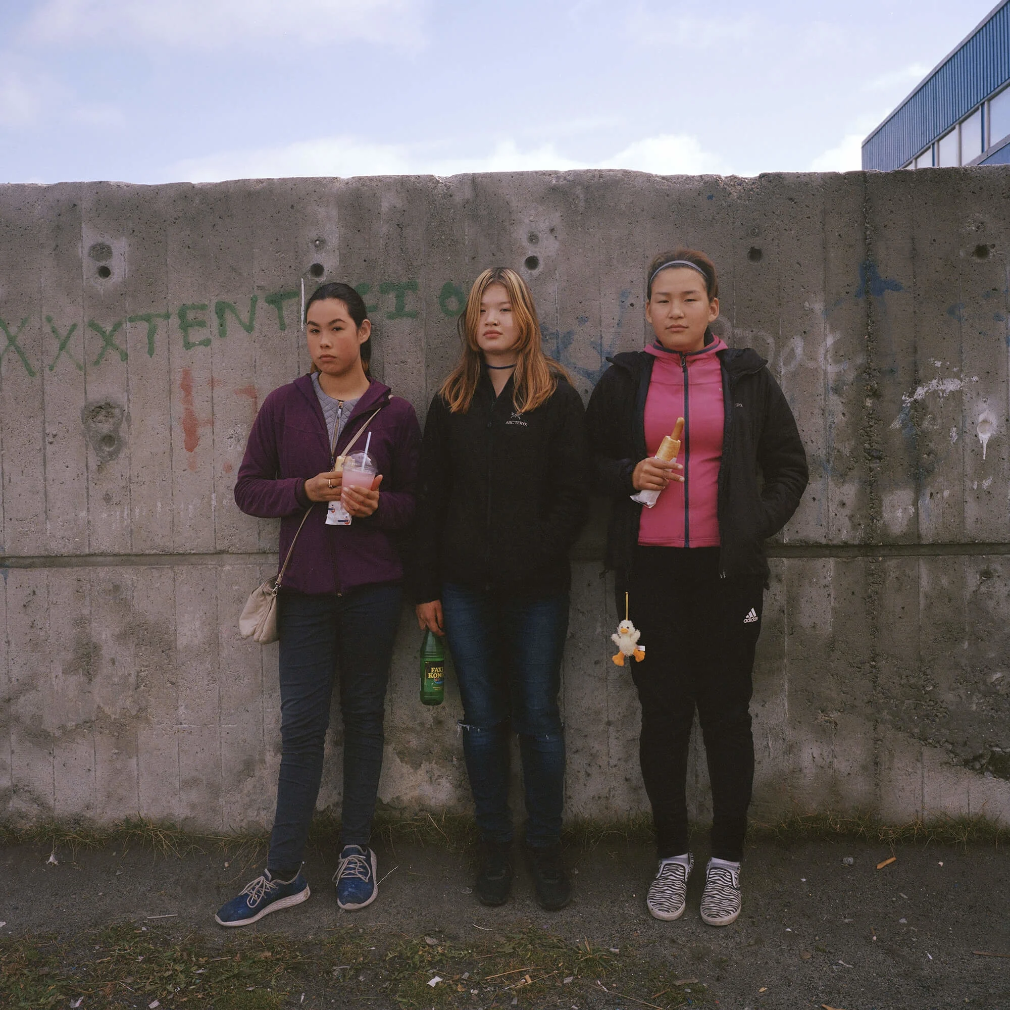 Naja, Nuka and Theis, three 14-year-old friends hanging out during their lunch break outside their school. The graffiti on the wall behind them says: “I love you Billie Eilish.”