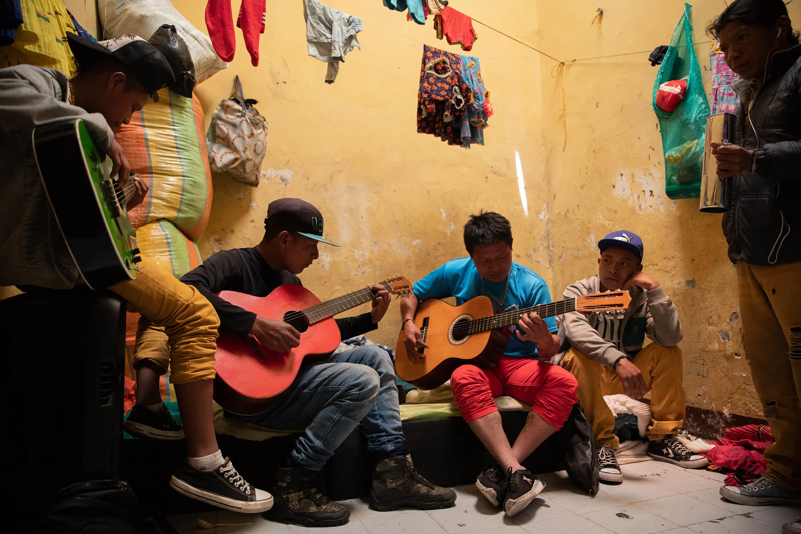 L: The band Chocobida formed after being displaced. They sing songs in their native Embera recalling their experiences such as “We Came to Bogota Because We Were Forced To”. R: A woman makes use of available space to hang her traditional dresses to dry