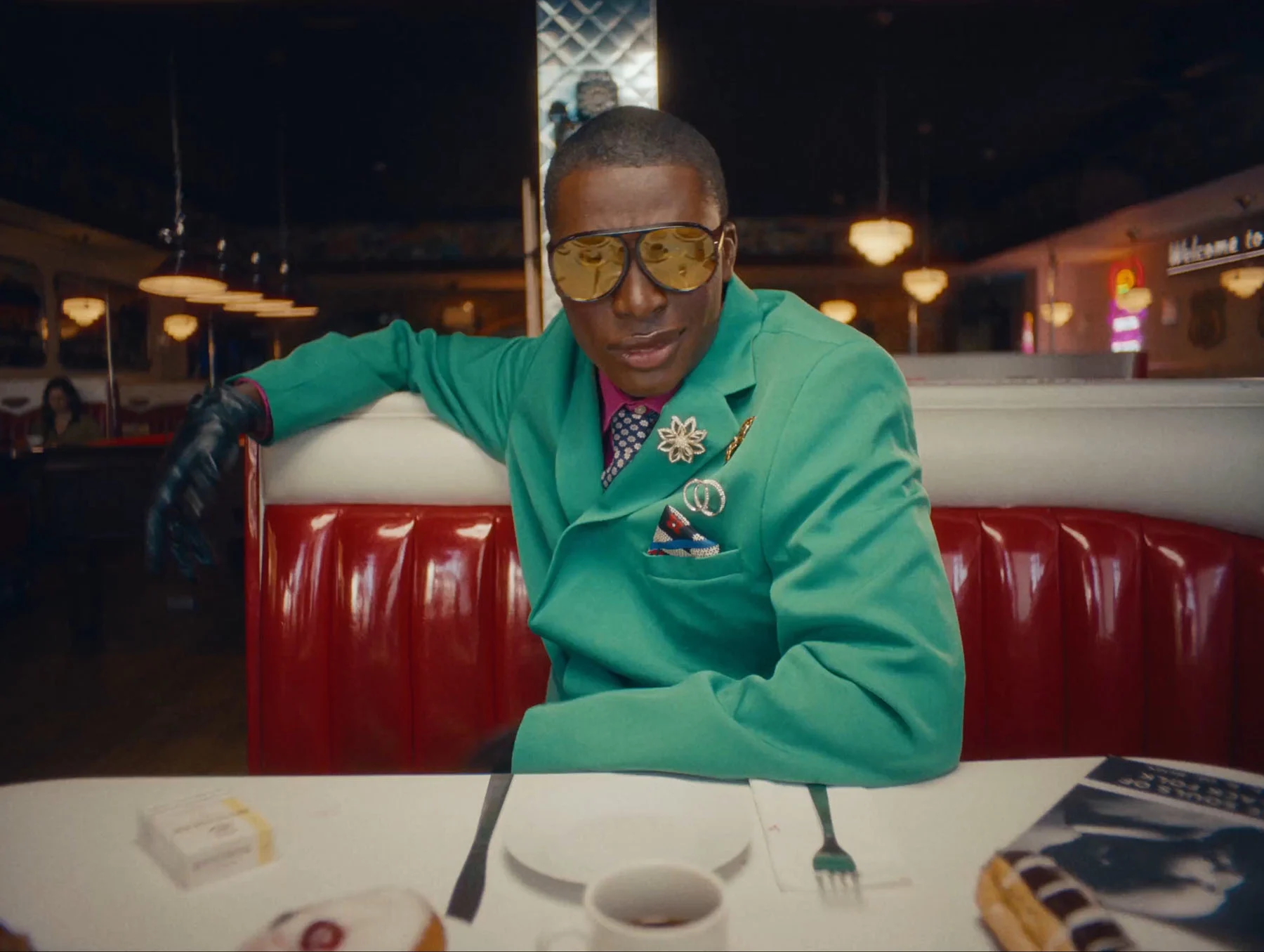 A video showing two men speaking to each other across a table at an American-style diner. The camera cuts between the two men as the converse.