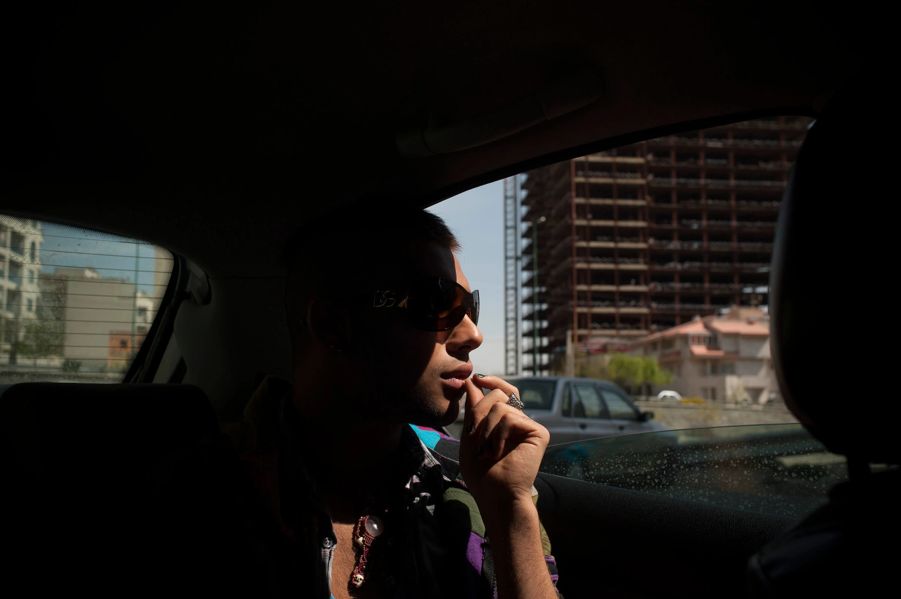 Amir (19) gazes out of the window on a ride along with his family and friends to Eram Wonderland outside of Tehran.