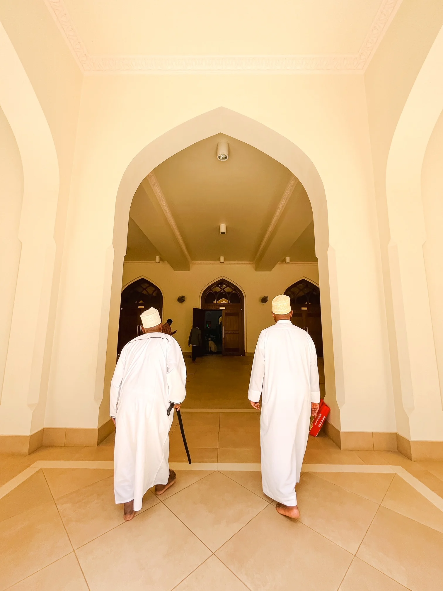 A photograph of two men walking into a building in Zanzibar, Tanzania. 