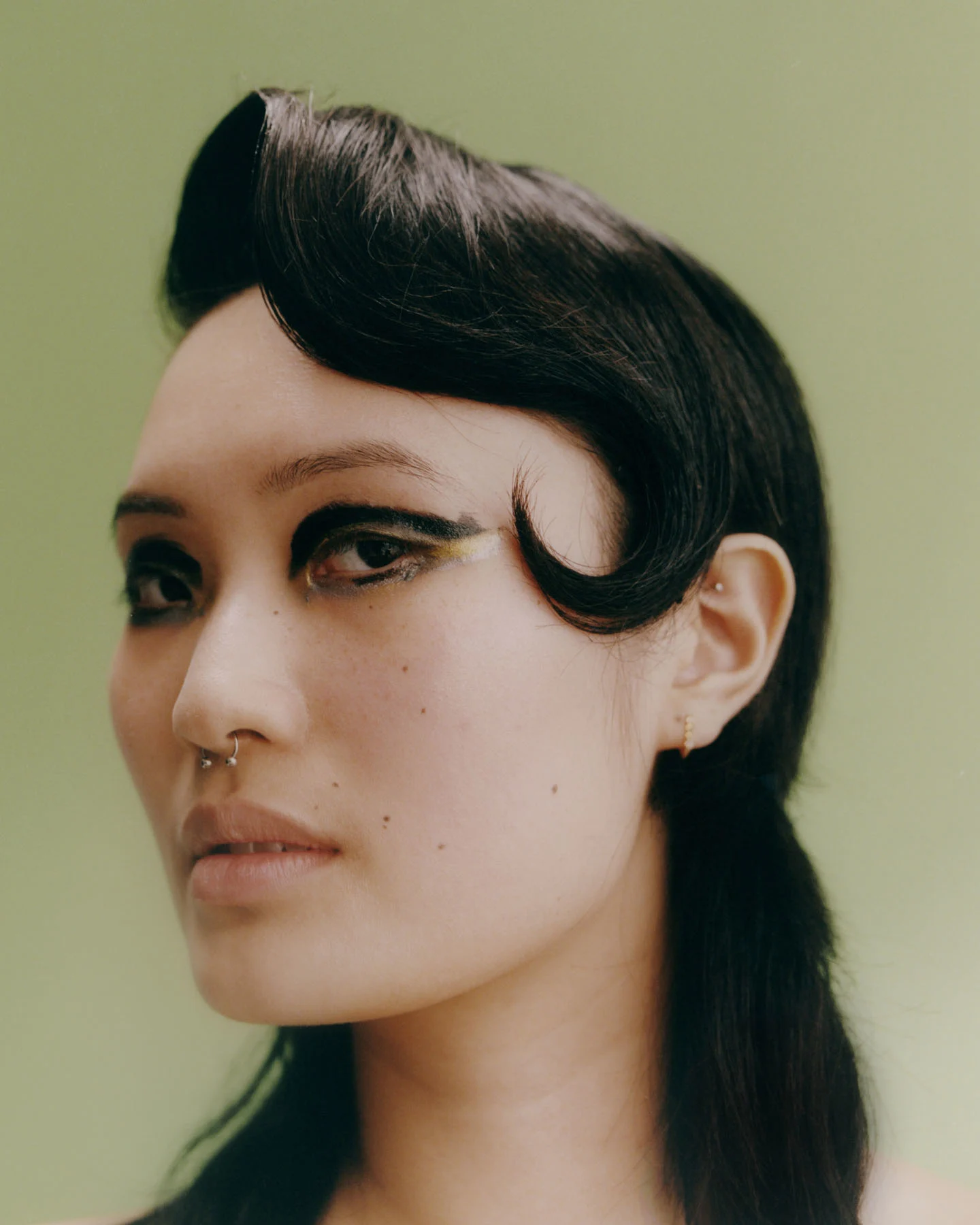 A photograph taken in the studio of model Chris Moon looking at the camera, with makeup by Linda Gradin and hair by Jerome Cultrera.
