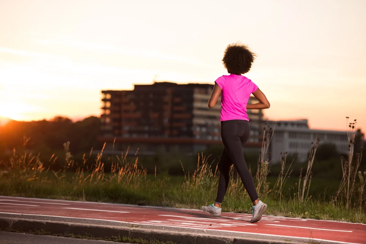 Alcohol Addiction: Woman exercising while the sun is setting