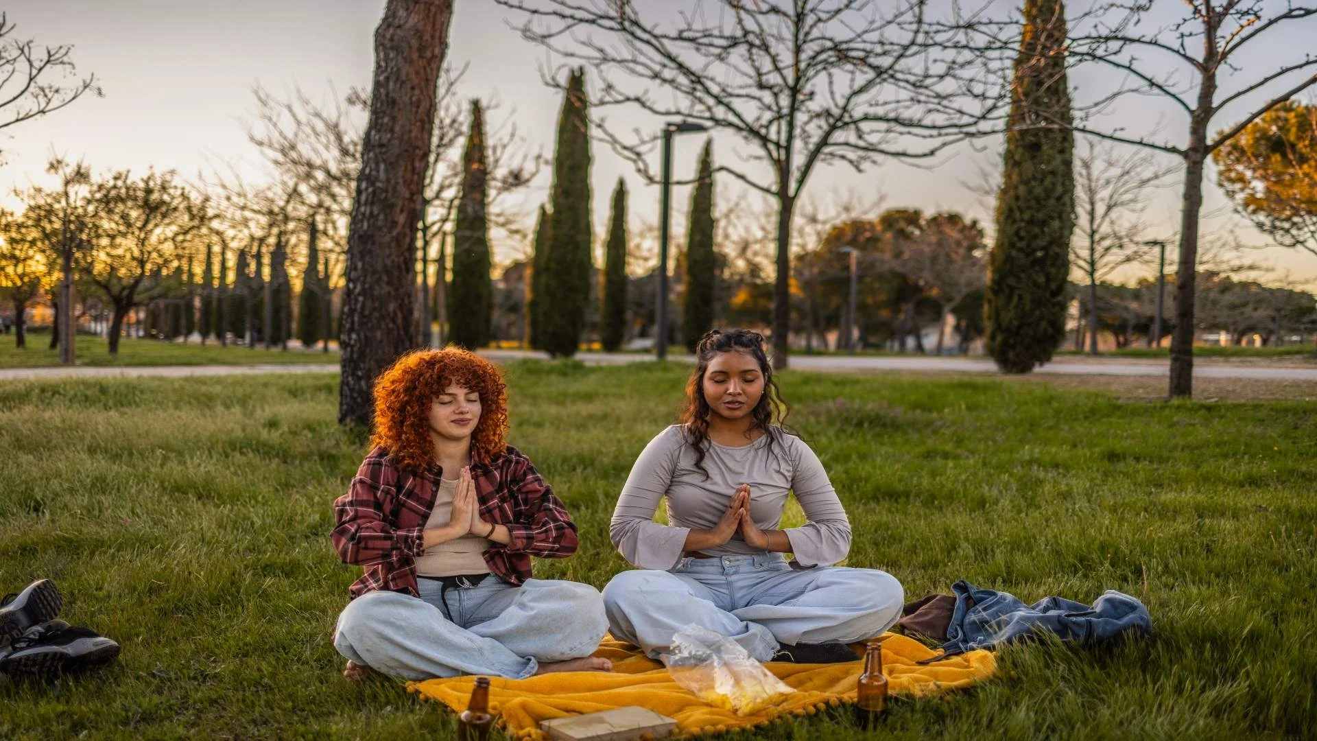 two-young-women-meditating-in-park-at-sunset-after-2025-05-05-16-46-43-utc
