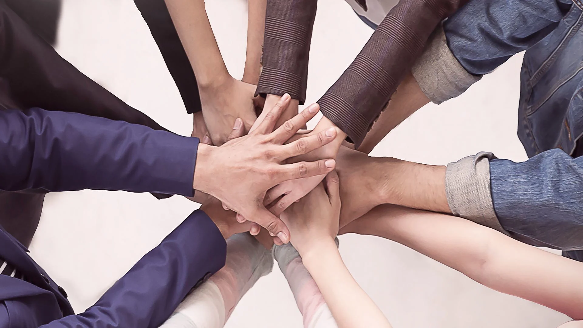 Multiple hands joined together in support, symbolizing solidarity, empathy, and how to help someone with depression through connection and community.